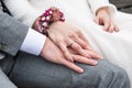 Bride holding groom hand with wedding rings sitting on bench Royalty Free Stock Photo