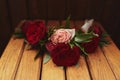 The bride holding in hand close-up the groom`s buttonhole flowers with white roses, and green and greenery Royalty Free Stock Photo