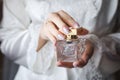 Bride holding in hands a flacon of luxury perfume