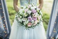 Bride holding in hands small wedding bouquet light pink and white roses Royalty Free Stock Photo