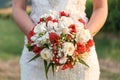 Bride holding her bouquet of red and white flowers Royalty Free Stock Photo
