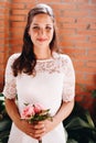 Bride holding her small wedding bouquet of pink roses. Wedding day concept