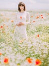 The bride is holding the poppy flowers in the poppy field.