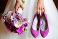 Bride holding shoes and colorful bouquet Royalty Free Stock Photo