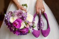 Bride holding shoes and colorful bouquet Royalty Free Stock Photo