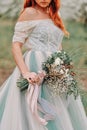 The bride is holding a spring wedding bouquet, close-up