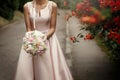 Bride holding wedding bouquet of pink roses and white flowers in Royalty Free Stock Photo