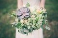 Bride holding the wedding bouquet, with succulent flowers,