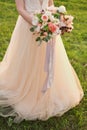 Bride holding a wedding fine-art bouquet in pastel pink colors. closeup.