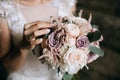 The bride holds a beautiful wedding bouquet of pink and white flowers in her hands Royalty Free Stock Photo