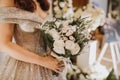 The bride holds a bouquet on the wedding day