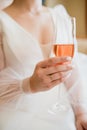 The bride holds a glass of delicious champagne