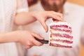 Bride holds piece of wedding cake in her hands and gives groom Royalty Free Stock Photo