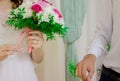 The bride holds a wedding bouquet in her hand.