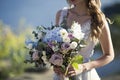 Bride holds wedding bouquet on nature background