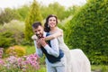 Bride hugs groom from the back on nature green background Royalty Free Stock Photo