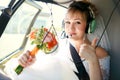 Bride inside helicopter preparing to fly, in headset, thumbs up.