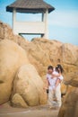 Bride jumped on the groom`s back in the rocks against the sky