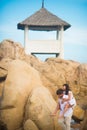 Bride jumped on the groom`s back in the rocks against the sky and a lonely house