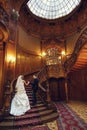 Bride kisses groom's cheek while he plays on the piano Royalty Free Stock Photo