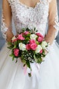 Bride in a lace dress holding a wedding bouquet of white and pink roses Royalty Free Stock Photo