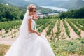 The bride laughs and rejoices in the sunny day. The girl holds a chic bouquet of flowers in her hands and walks among Royalty Free Stock Photo