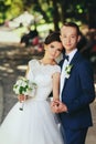 Bride leans to a groom while he holds her tender hand Royalty Free Stock Photo