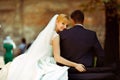 Bride leans to groom's shoulder sitting with him on a retro car Royalty Free Stock Photo