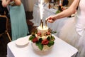 Bride lights fireworks on wedding cake on a light tablecloth