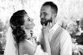 the bride with long curls gently strokes the groom in a blue suit on the cheek.