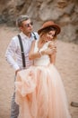 Bride and groom stand and smile in canyon against background of rocks. Closeup.