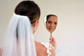 Bride looks at herself in the mirror on her Wedding Day