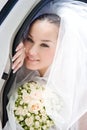 Bride looks out from the open door of the car Royalty Free Stock Photo