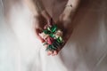 Bride in a luxurious wedding dress holding a wedding buttonhole made of roses Royalty Free Stock Photo