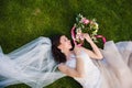 Bride lying in the grass with wedding bouquet