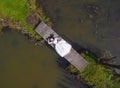 The bride is lying on a wooden bridge, barefoot. Top view