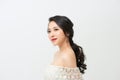 The bride in a magnificent white dress stands back and looks over her shoulder