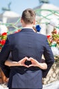 Bride making a heart sign while her arms are around her groom. Royalty Free Stock Photo