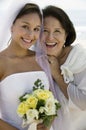 Bride and mother with flowers smiling (close-up) (portrait)