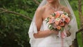 The bride is nervous before the wedding. Bride holding a perfume. nice wedding bouquet in bride`s hand. Bride is holding