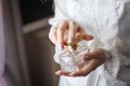 Bride opening a flacon of a fragrant perfume