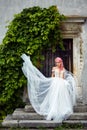 Bride with pink hair poses before a grey wall with green ivy Royalty Free Stock Photo