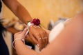 Bride places a flower corsage on the hand of her maid of honor