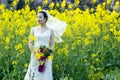 Bride portraint with white wedding dress in cole flower field Royalty Free Stock Photo