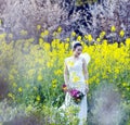 Bride portraint with white wedding dress in cole flower field Royalty Free Stock Photo