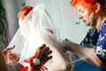 Bride is preparing for the wedding. bridesmaid helps the girl to put on her dress. Royalty Free Stock Photo