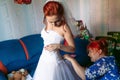 Bride is preparing for the wedding. bridesmaid helps the girl to put on her dress. Royalty Free Stock Photo