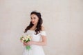 Bride Princess stands in a wedding dress with flowers