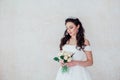 Bride Princess stands in a wedding dress with flowers