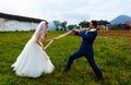 Bride pulling her groom to her with a rope - funny wedding concept.